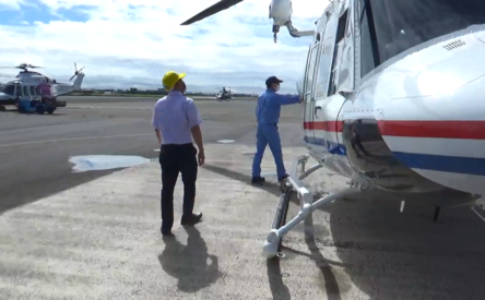 エプロン上で、ヘリコプターの点検・運航準備を行う関係者の様子