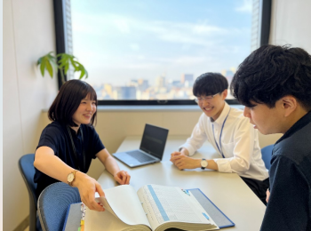 東京航空局で3人が向かい合って会議をする様子